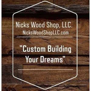 Nick's woodshop logo with white outline on wooden board