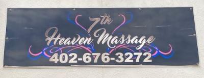 7th Heaven Massage sign with black background and purple hearts