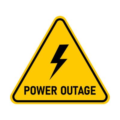 Yellow triangle sign with lightning bolt in the middle and the words power outage